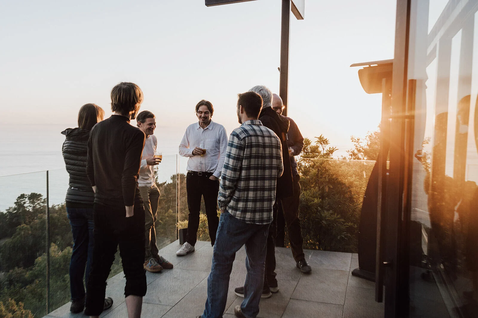 Participants in conversation on an outdoor terrace at a previous PL Neuro retreat
